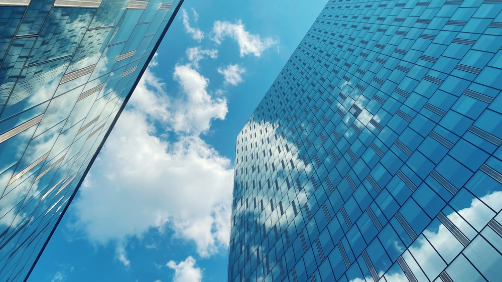 view from bottom of glass facade of skyscraper