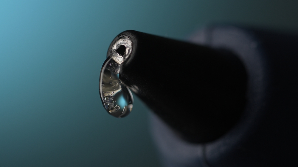 Glue,Gun,Nozzle,With,Hot,Liquid,Glue.,Close-up,,Shallow,Dof.